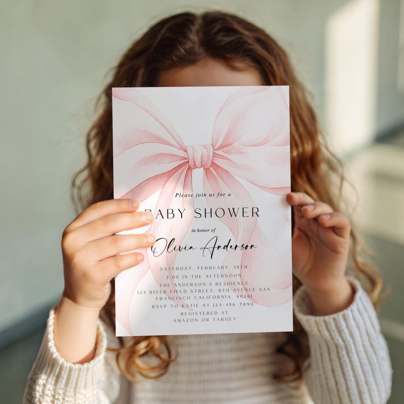 May include: Baby shower invitation with a watercolor pink bow design. The invitation includes the text "Please join us for a BABY SHOWER in honor of Olivia Anderson". Additional details include the date, time, and location.