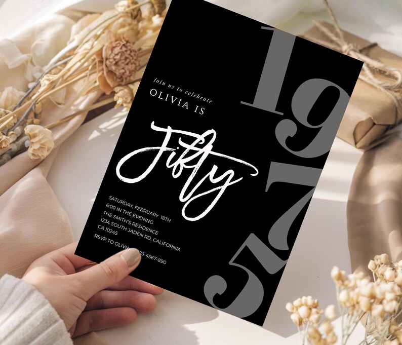 May include: Black invitation card with white script text that reads "Olivia is Fifty." The number "197" is in gray on the right side. Additional text includes the date, time, and location of the event.