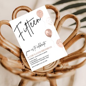 May include: A white invitation card with the word "Fifteen" in black script. The card is decorated with rose gold balloons and confetti. The text on the card reads "Join us to celebrate Katie's 15th Birthday, Saturday, August 15th at 6:00 PM, Kate's House, 121 Riverfred Street, 5th Avenue, San Francisco, California, 90264, RSVP to Mom at 123-456-7890."