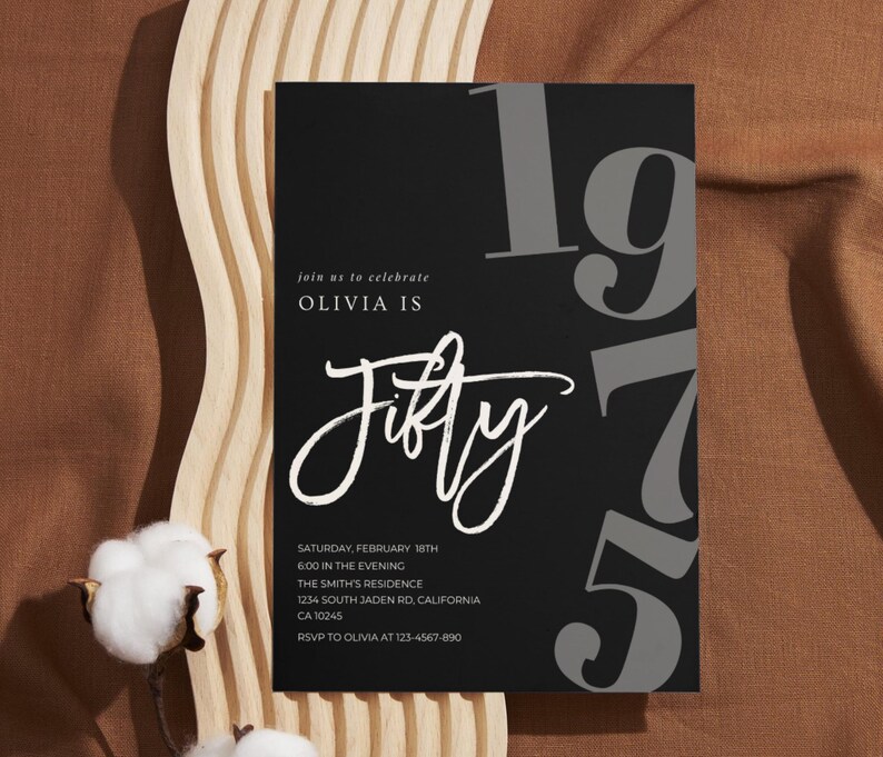 May include: Black birthday invitation with the text "Olivia is Fifty" in white script. The number "1975" is in gray, with event details below. The invitation is on a brown surface with cotton flowers and a wooden accent.