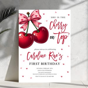 Op de afbeelding: Een roze en rode kers op de taart verjaardagsinvitation met de tekst "She is the Cherry on Top" en "Caroline Rae's First Birthday". De uitnodiging bevat de datum, tijd, locatie en RSVP-informatie.