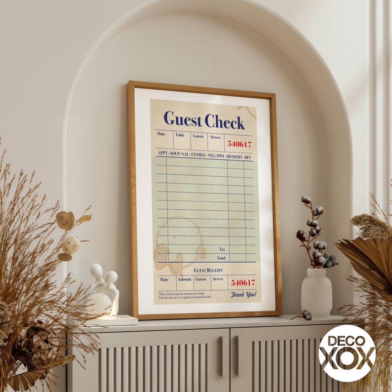 May include: A framed print featuring a vintage-style "Guest Check" design. The print has a beige background with a grid of lines for item entries, and includes the text "Guest Check", "Guest Receipt", and "Thank You!" in a retro font.