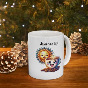 Puede incluir: Taza de café de cerámica blanca con un sol sonriente y una taza de café sonriente con el texto "Java nice day!" impreso en ella.