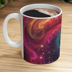 May include: White ceramic coffee mug with a colorful abstract design featuring swirling lines and glowing dots. The design resembles a galaxy or nebula.