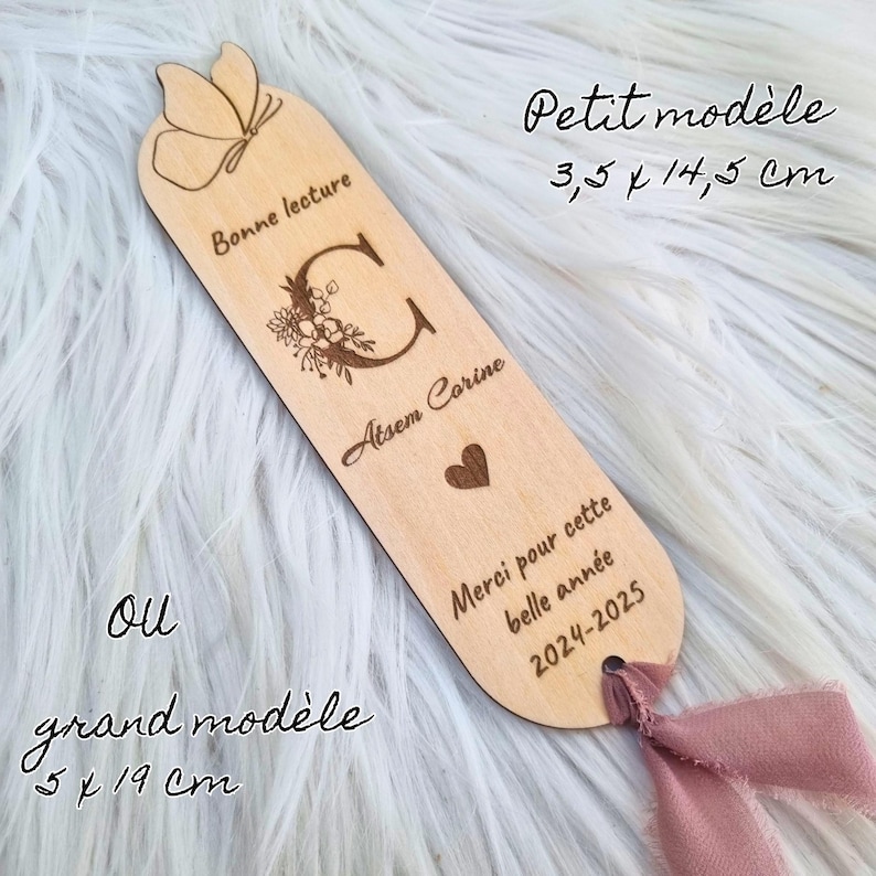 May include: A wooden bookmark with a butterfly design at the top, measuring 3.5 x 14.5 cm. The bookmark features the text "Bonne lecture", a floral "C", the name "Atsem Corine", a heart, and the text "Merci pour cette belle ann&eacute;e 2024-2025".