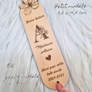 May include: A wooden bookmark with a floral design at the top and a pink ribbon. The bookmark has the text "Bonne lecture", "Ma&icirc;tresse Alicia", "Merci pour cette belle ann&eacute;e 2024-2025", and the dimensions 3.5 x 14.5 cm or 5 x 19 cm.
