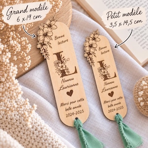 May include: Two light-colored wooden bookmarks with rounded ends and sage green fabric tassels. Each features a floral design, the letter L, the text Bonne lecture, Nannou Laurianne, a heart, Merci pour cette belle ann&eacute;e, and 2024-2025.