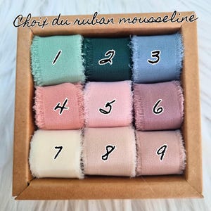May include: A selection of nine chiffon ribbons in a cardboard box. The ribbons are in various colors, including shades of green, blue, pink, and beige. Each ribbon is labeled with a number from 1 to 9. The text "Choix du ruban mousseline" is at the top.