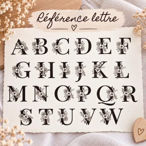 May include: A rectangular sheet of off-white paper featuring the black text R&eacute;f&eacute;rence lettre and a heart symbol. Below, the alphabet from A to W is displayed in a bold black serif font, with each letter decorated with black floral illustrations.