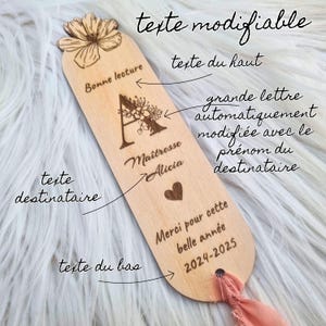 May include: A wooden bookmark with engraved text and a floral design. The bookmark features the words "Bonne lecture", "Ma&icirc;tresse Alicia", and "Merci pour cette belle ann&eacute;e 2024-2025". A pink ribbon is attached.