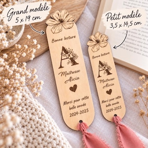 May include: Two light-colored wooden bookmarks with rounded ends and pink fabric tassels. Each features a laser-engraved flower at the top, the letter A with floral details, the text Bonne lecture, Ma&icirc;tresse Alicia, a heart, and 2024-2025.