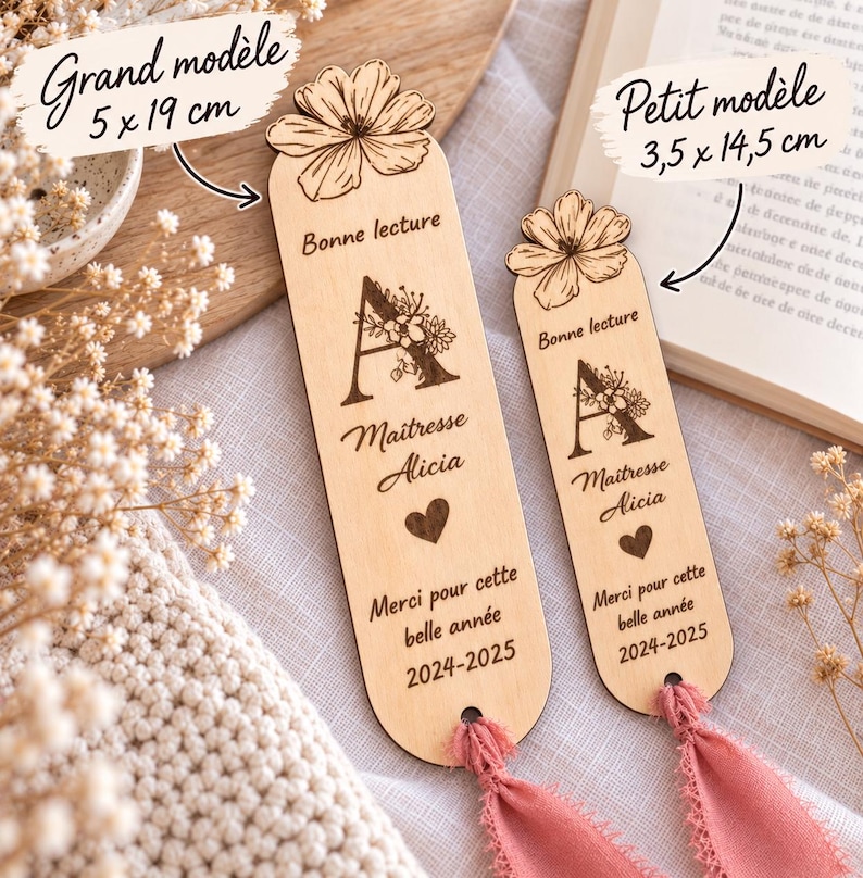 May include: Two light-colored wooden bookmarks with rounded ends and pink fabric tassels. Each features a laser-engraved flower at the top, the letter A with floral details, the text Bonne lecture, Ma&icirc;tresse Alicia, a heart, and 2024-2025.