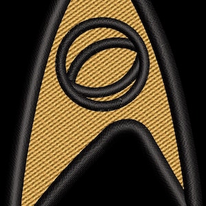 May include: Embroidered gold and black Starfleet insignia patch. The patch features a gold arrowhead shape with a textured surface, outlined in black. A black circle design is in the centre. The background is black.
