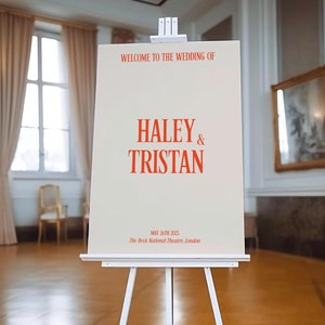 May include: A white easel with a sign announcing the wedding of Haley & Tristan on May 26th, 3025 at The Deck National Theatre, London.