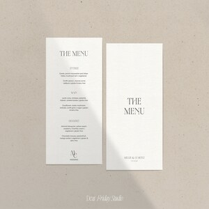 May include: Two white cards with black text. The card on the left has the text "THE MENU" and lists the menu items for a wedding reception. The card on the right has the text "THE MENU" and the text "MR & MRS WITZ" at the bottom.
