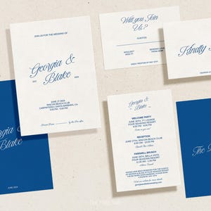 May include: A collection of wedding stationery in navy blue and cream. The invitations feature elegant script with the names "Georgia & Blake" and event details. Includes RSVP, welcome party, and details cards.