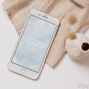 Puede incluir: Una invitación digital para una despedida de soltera con un fondo de acuarela azul y el texto "The Bride is on Cloud Nine" y "Veronica Smith" con la fecha y la hora del evento.