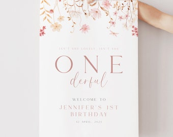 Könnte beinhalten: Ein weißes Poster mit rosa Blumenillustrationen oben. Der Text lautet "Isn't she lovely, isn't she One derful. Welcome to Jennifer's 1st Birthday. 12 April, 2023."