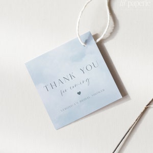 May include: A light blue thank you tag with a watercolor background. The tag says "Thank you for coming" with a small heart and "Veronica's Bridal Shower".