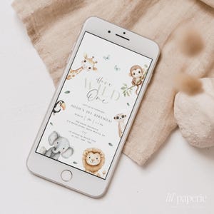 May include: A digital invitation for a first birthday party with a jungle theme. The invitation features a giraffe, monkey, toucan, elephant, and lion. The text on the invitation reads "Here's Wild One" and "Adam's 1st Birthday".