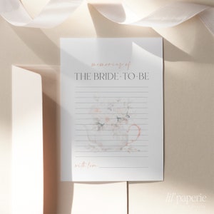 May include: A printable bridal shower card with a watercolor illustration of a teacup filled with flowers. The card has the text "memories of THE BRIDE-TO-BE with love..." and the text "lil' paperie" at the bottom.