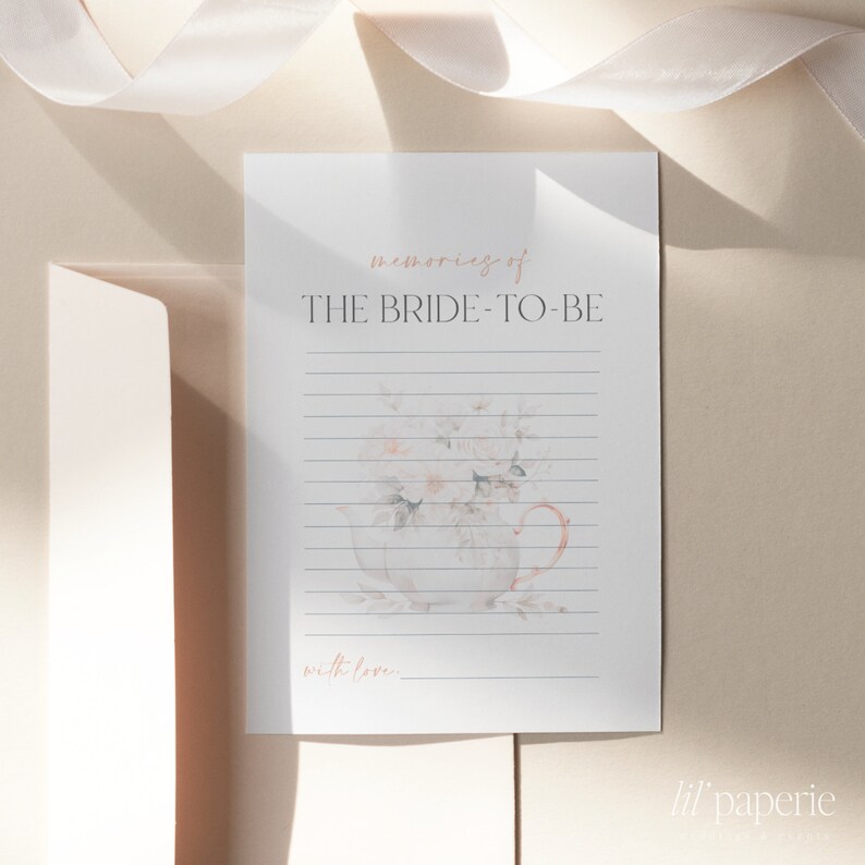 May include: A printable bridal shower card with a watercolor illustration of a teacup filled with flowers. The card has the text "memories of THE BRIDE-TO-BE with love..." and the text "lil' paperie" at the bottom.