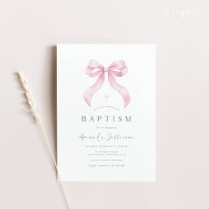 K&ouml;nnte beinhalten: Eine wei&szlig;e Taufeinladung mit einer rosa Aquarell-Schleife und einem Kreuz. Der Text lautet: "Feiern Sie mit uns die Taufe unserer Tochter Amanda Jefferson. Samstag, 8. Oktober um 14:00 Uhr. St. Michael's Church, 14 North Street, Santa Monica, Kalifornien. Mittagessen im Anschluss im Cafe Blue. RSVP an Sarah unter 123-456-7890."