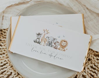 May include: White favor box with gold trim featuring a watercolor illustration of a line of safari animals, including a giraffe, elephant, lion, and zebra. The text "Thank you for coming! Love from Andrew" is printed on the box.