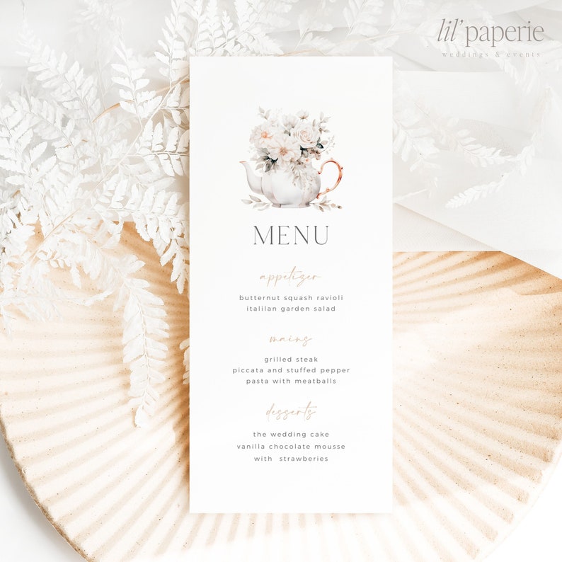 May include: A white menu card with a watercolor illustration of a teapot with flowers. The menu lists appetizers, mains, and desserts. The text reads: "MENU, appetizer, butternut squash ravioli, Italian garden salad, mains, grilled steak, piccata and stuffed pepper, pasta with meatballs, desserts, the wedding cake, vanilla chocolate mousse with strawberries."