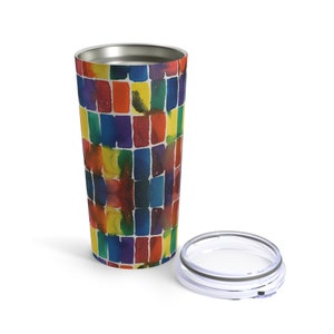 May include: A stainless steel tumbler with a colorful abstract pattern of watercolor squares in shades of red, orange, yellow, green, blue, and purple. The tumbler has a lid with a clear plastic lid.