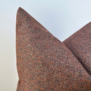 May include: Two brown and black patterned throw pillows with a textured woven fabric.