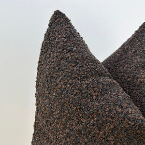 May include: Two brown, triangular-shaped cushions with a textured surface.
