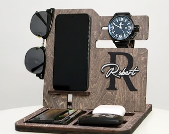 May include: A wooden desk organizer in a dark brown finish. It holds a smartphone, sunglasses, a watch, wallet, and wireless earbuds. The organizer is personalized with the name "Robert" and the letter "R".