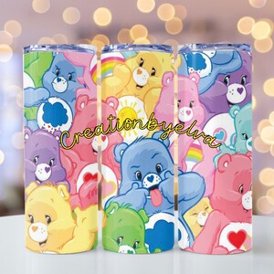 May include: Three colorful tumblers featuring a repeating pattern of Care Bears in various poses. The bears are in shades of blue, pink, yellow, purple, and green. The text "creationbyelva" is written in a cursive font on the tumblers.