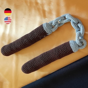 May include: A pair of brown crocheted nunchucks with a blue crocheted chain connecting them.