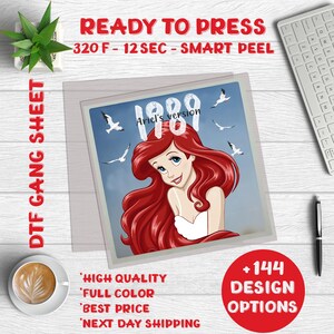 May include: A ready-to-press iron-on transfer sheet featuring a cartoon image of Ariel from The Little Mermaid. The image is set against a blue sky with seagulls flying overhead. The text "Ariel's version 1989" is included in the design.
