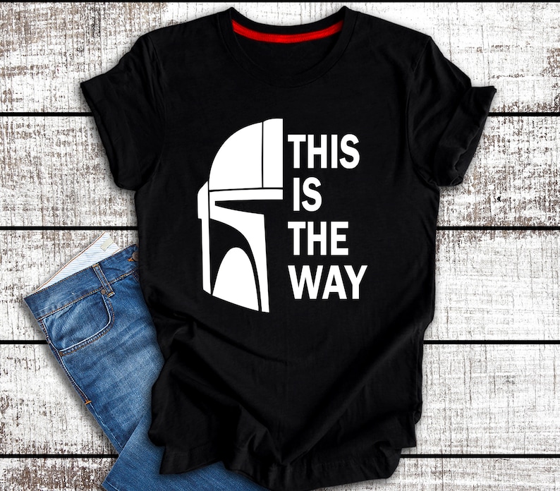 May include: Black t-shirt with a white graphic of a Mandalorian helmet and the text "This is the way".