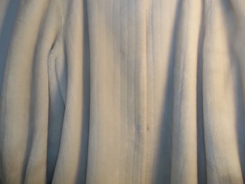 Puede incluir: Una chaqueta de forro polar blanca con cierre de cremallera.