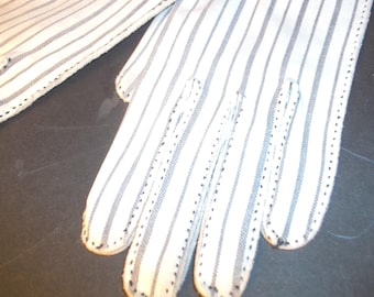 May include: White gloves with vertical gray stripes. The gloves have a classic design with a stitched border and are made of a lightweight fabric. The fingers are individually stitched, and the gloves appear to be unworn.