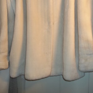 Puede incluir: Una chaqueta de piel sint&eacute;tica blanca de manga larga con cierre de bot&oacute;n.