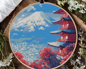 Op de afbeelding: Een borduurring met een kleurrijk beeld van de Mount Fuji, een rode pagode en kersenbloesems. De borduurwerk is in een gepixelde stijl gemaakt.