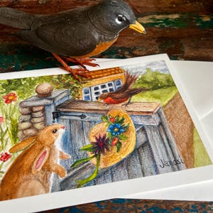 Tarjeta de felicitación en blanco plegada con ilustración de acuarela y lápiz de color de Bellas Artes con conejito y petirrojo