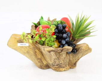 May include: A wooden fruit bowl carved from a tree root, filled with artificial fruit and greenery. The bowl has a natural, rustic look and is perfect for displaying fruit or other decorative items.
