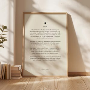 Könnte beinhalten: Gerahmter Druck mit einem Zitat von Steve Jobs auf cremefarbenem Hintergrund. Der Text enthält das Wort „TOD“ und das Apple-Logo. Der Druck befindet sich in einem hellen Holzrahmen und wird auf einer Holzoberfläche angezeigt.