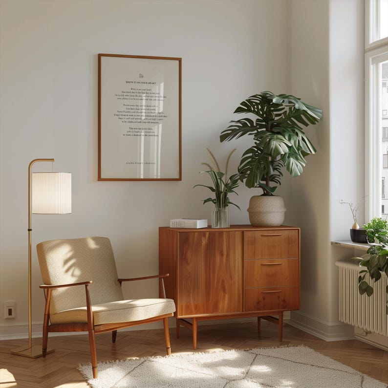 May include: A mid-century modern living room with a wooden cabinet, a beige armchair, a floor lamp, and a framed print with the text "Write it in your heart".