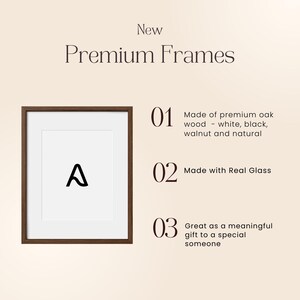 May include: A framed print with a dark brown wooden frame and a white mat. The print features a black letter "A". Text on the image reads "New Premium Frames" and details about the frames, including real glass and premium oak wood.