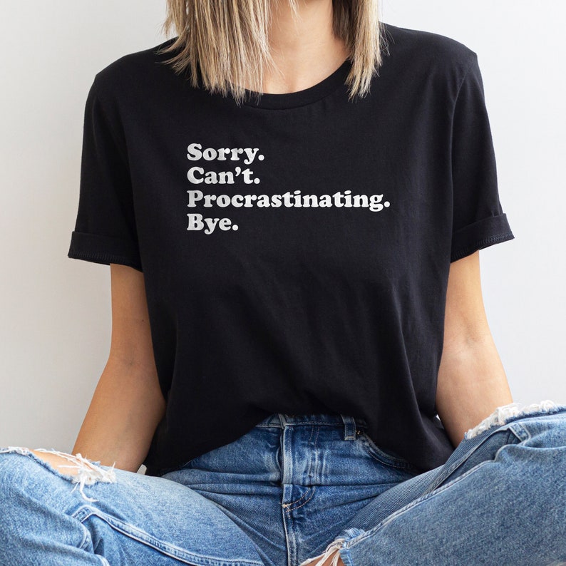 May include: A black t-shirt with white text that reads "Sorry. Can't. Procrastinating. Bye."