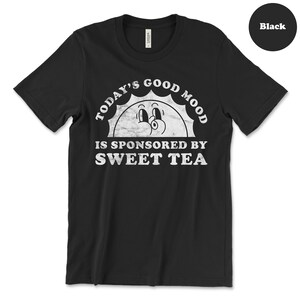 May include: Black t-shirt with a white graphic of a smiling sun with the text "Today's Good Mood Is Sponsored By Sweet Tea."