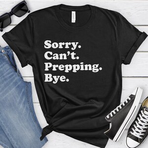 May include: Black t-shirt with white text that reads "Sorry. Can't. Prepping. Bye."