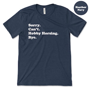 May include: A heather navy blue t-shirt with the text "Sorry. Can't. Hobby Horsing. Bye." printed in white.